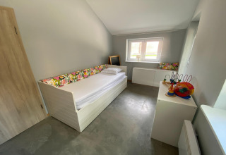 Lichte en ruime kamer in lodge «Le coeur du brâme» in België met eenpersoonsbed en speelgoed.