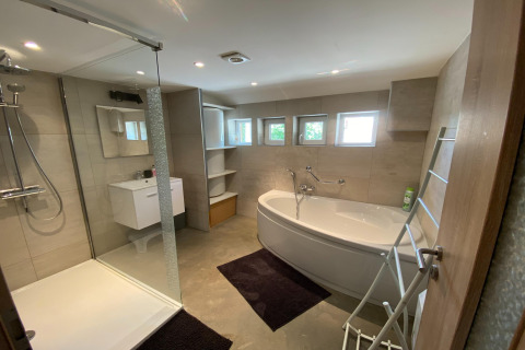 Modern badkamer bij lodge «Le coeur du brâme» in België met douche, bad en kleine ramen.
