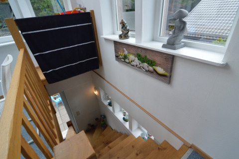 Trap met houten leuning, 'Relax' bord en decoraties in een sfeervolle lodge in België.