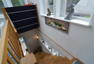 Trap met houten leuning, 'Relax' bord en decoraties in een sfeervolle lodge in België.