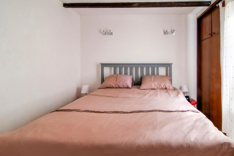 Cozy bedroom featuring a double bed, wooden beams, and natural light at Au Coeur du Pêcheur in Belgium.