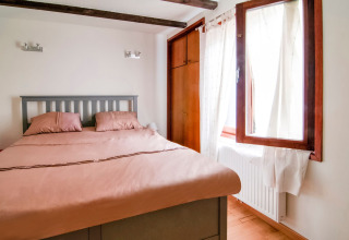 Cozy bedroom with a double bed and open window at Au Coeur du Pêcheur lodge in Belgium, naturally lit.