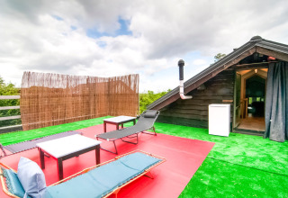 Rooftop terrace at Au Coeur du Pêcheur lodge in Belgium featuring lounge chairs, tables, and artificial grass.