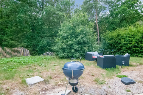 Outdoor area at Au Coeur du Pêcheur lodge in Belgium featuring a barbecue grill and garden furniture.