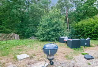 Outdoor area at Au Coeur du Pêcheur lodge in Belgium featuring a barbecue grill and garden furniture.