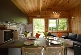 Gemütliche Küche und Wohnzimmer in Le Chalet Chaleureux B, Belgien, mit Holzwänden und moderner Einrichtung.