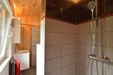Modernes Badezimmer im Le Chalet Chaleureux B in Belgien mit Dusche, Fliesen und Holzdecke.