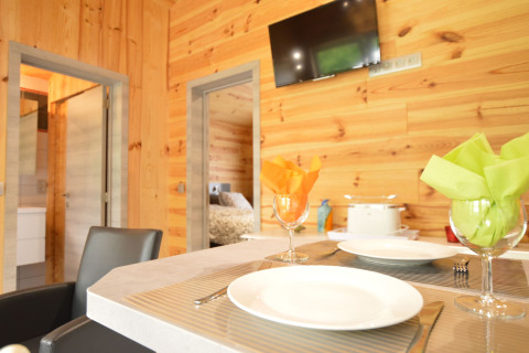 Essbereich mit Holzverkleidung und gedecktem Tisch im Le Chalet Chaleureux B in Belgien.