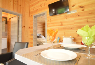 Essbereich mit Holzverkleidung und gedecktem Tisch im Le Chalet Chaleureux B in Belgien.