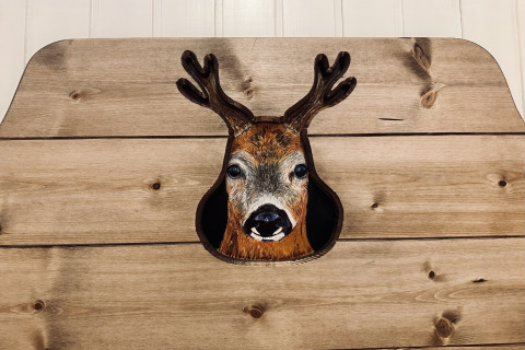 Decoratief hertenhoofd aan een houten wand, gefotografeerd in chalet ‘La Cabane’ in België.