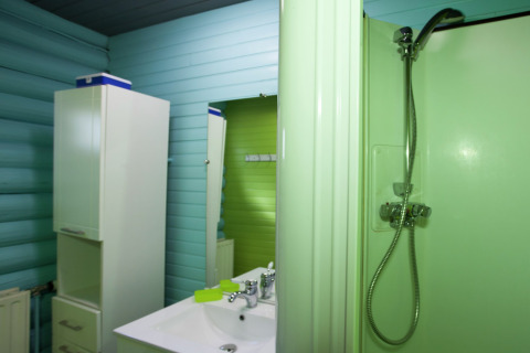 Badezimmer im Chalet Les Muguets in Belgien mit Dusche, Waschbecken, Spiegel und blauen Wänden.