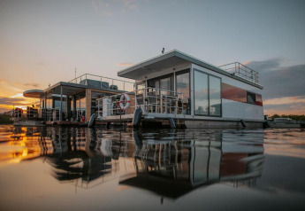 Péniche moderne à Zehdenick sur l’eau au coucher du soleil, avec de superbes reflets et atmosphère paisible.