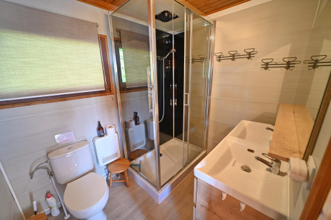 Moderne badkamer in chalet Hortensias, België, met glazen douche, dubbele wastafel en toilet.