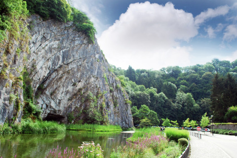 Naturskønt udsigt ved La Ribambelle i Belgien med klipper, grøn vegetation og rolig flod.