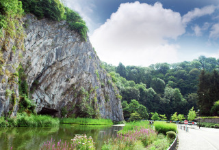 Naturskønt udsigt ved La Ribambelle i Belgien med klipper, grøn vegetation og rolig flod.