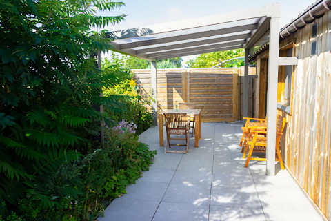 Terrasse extérieure du Chalet de Bioul en Belgique avec salon de jardin en bois et verdure luxuriante.