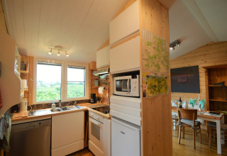 Cuisine et salle à manger en bois moderne au Chalet de Bioul, Belgique, avec fenêtres et vue.