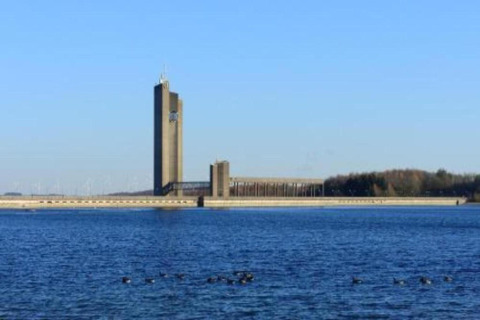 Udsigt over vandet mod en moderne bygning ved en dæmning nær La Ribambelle-lodgen i Belgien
