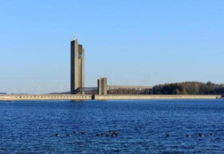 Udsigt over vandet mod en moderne bygning ved en dæmning nær La Ribambelle-lodgen i Belgien