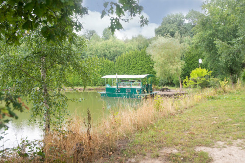 Woonboot 'Le Bateau du Lac Privé' ligt op een rustig meer omgeven door groen in België.