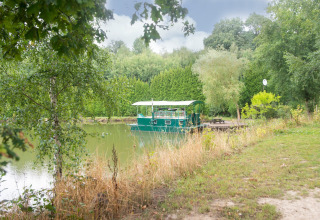 Woonboot 'Le Bateau du Lac Privé' ligt op een rustig meer omgeven door groen in België.