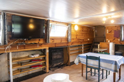 Woonruimte in woonboot 'Le Bateau du Lac Privé' in België, met eettafel en tv aan de muur.