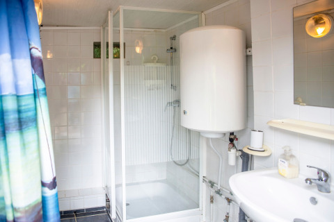 Badkamer op woonboot 'Le Bateau du Lac Privé' in België met douche, wastafel en boiler.