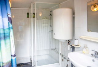 Badkamer op woonboot 'Le Bateau du Lac Privé' in België met douche, wastafel en boiler.