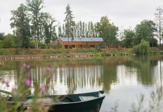 Le Bateau du Lac Privé woonboot aan een rustige vijver, omgeven door bomen en natuur in België.