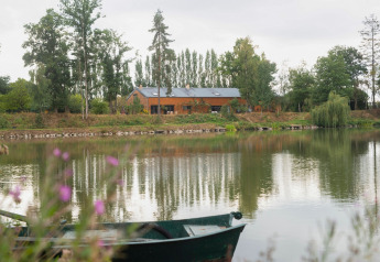 Casa galleggiante Le Bateau du Lac Privé accanto a un lago sereno, circondata da natura e alberi in Belgio.