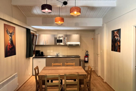 Binnenzicht op keuken en eetplaats van chalet OREE DU BOIS in België met dierenportretten aan de muren.