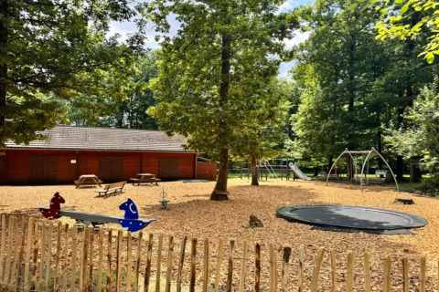 Parque infantil en el chalet OREE DU BOIS en Bélgica con columpios, tobogán, trampolín y cabaña de madera.