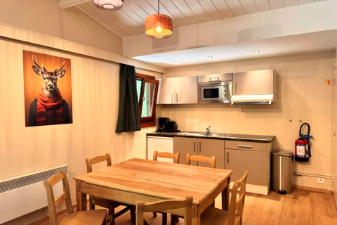 Moderne chaletkeuken in 'OREE DU BOIS' België met houten tafel en grappige afbeelding van een hert.