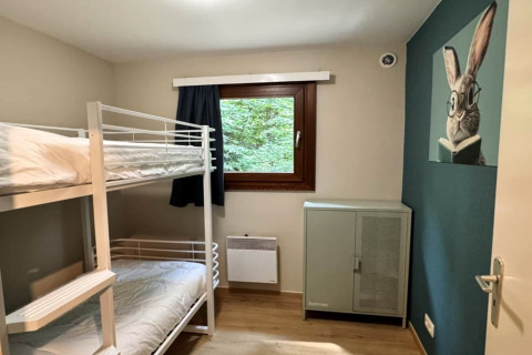 Kamer met stapelbed, raam met gordijn, kast en konijnenschilderij, chalet OREE DU BOIS, België.