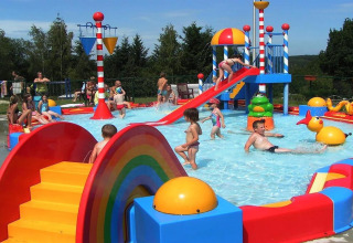 Bambini che giocano in una piscina colorata con scivolo e giochi al Holiday Park Ardinam 1 in Belgio.