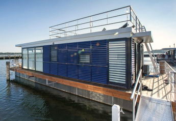 Moderne Hausboot 'Floating Houses Blue Active' am Steg in Ribnitz-Damgarten, Deutschland, bei Sonnenschein.