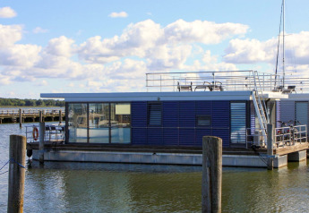 Modernes Hausboot 'Luisa' in Ribnitz-Damgarten, mit großzügigen Fenstern und sonniger Dachterrasse.
