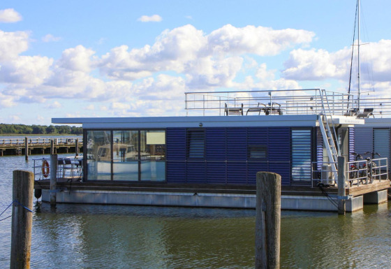 Modernes Hausboot 'Luisa' in Ribnitz-Damgarten, mit großzügigen Fenstern und sonniger Dachterrasse.
