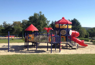Playground with slides and climbing structures at Holiday Park Ardinam 1 mobile home in Belgium on a sunny day.