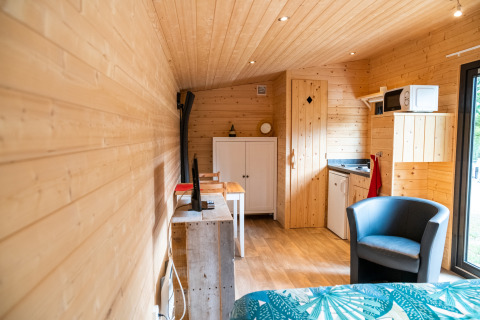 Interieur van mobilhome 'Holiday Park Ardinam 1' in België met houten wanden, kitchenette en zitplek.
