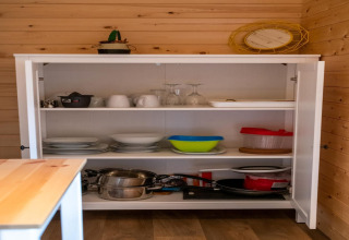 Credenza della cucina nella casa mobile Holiday Park Ardinam 1 in Belgio, con piatti e pentole.
