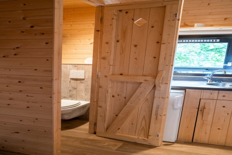 Vista interna della casa mobile Holiday Park Ardinam 1 in Belgio con pareti in legno, cucina e bagno.