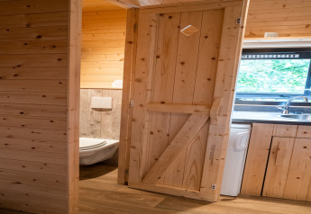 Vista interna della casa mobile Holiday Park Ardinam 1 in Belgio con pareti in legno, cucina e bagno.