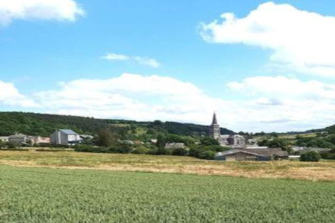 Uitzicht vanaf Holiday Park Ardinam 1 mobilhome in België op velden en een dorp met kerktoren.