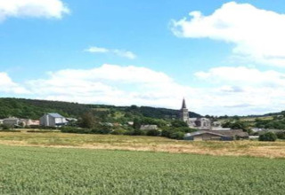 Panorama dal mobil home Holiday Park Ardinam 1 in Belgio con campi verdi e un villaggio con campanile.