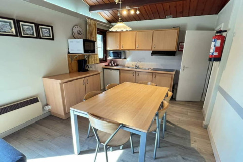 Cuisine moderne de chalet au LIJSTERNEST Belgique avec table en bois, chaises, meubles et puits de lumière.