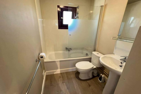 Salle de bain moderne du chalet LIJSTERNEST en Belgique, avec baignoire, toilettes et lavabo.