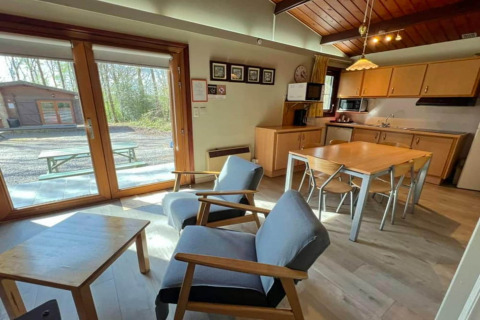Vue intérieure du chalet LIJSTERNEST en Belgique avec cuisine moderne, table à manger et espace salon.
