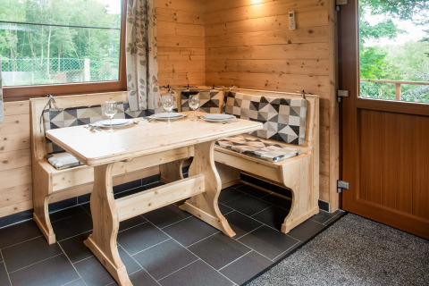 Knusse houten eethoek, gedekte tafel voor vier, Rogery 64 chalet in België met natuurlijk licht.