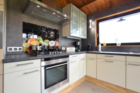 Moderne keuken in lodge Famenne te België, met een groot raam, fruitdecoratie en stijlvolle uitstraling.